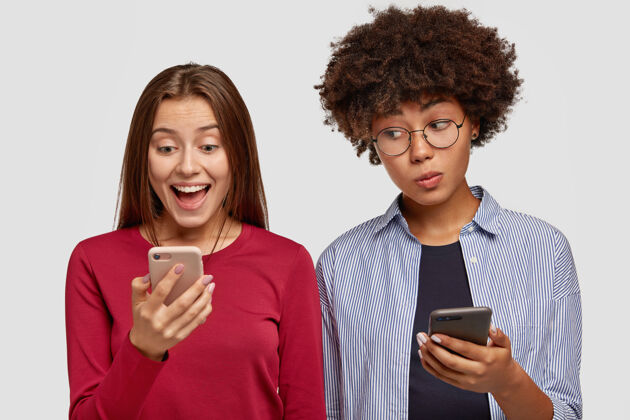 一起不同的女孩使用现代手机写博客水平邮件眼镜