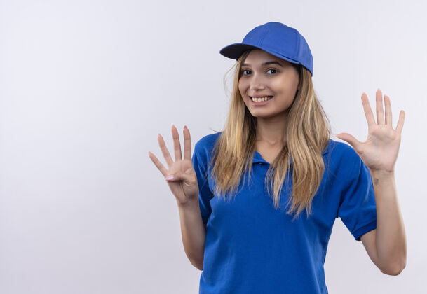 不同带着微笑的年轻送货员 穿着蓝色制服 戴着帽子 在白色的墙上显示着不同的号码 并留有复印空间年轻女孩交货