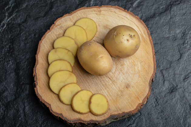 皮把土豆片或整片放在棕色木板上堆素食主义者生的