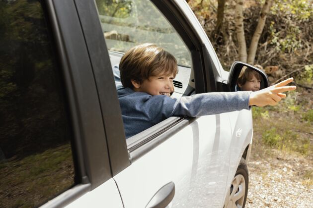 探索侧视图：孩子在车里 胳膊上有和平标志家庭旅行旅行