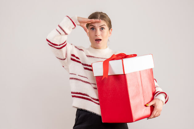 情绪拿着白色礼品盒的年轻女性看法礼物圣诞节