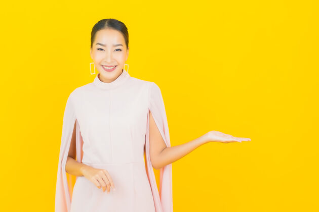 脸画像美丽的亚洲年轻女子微笑着在黄色的墙上有许多动作时尚乐趣日本人