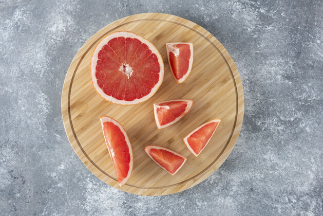食物切碎的酸葡萄柚放在木制的圆板上切割多汁口味