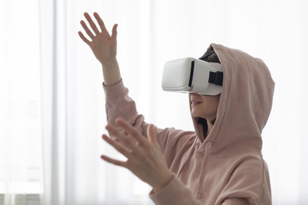 虚拟戴着虚拟现实护目镜玩电子游戏的年轻女子游戏控制台乐趣
