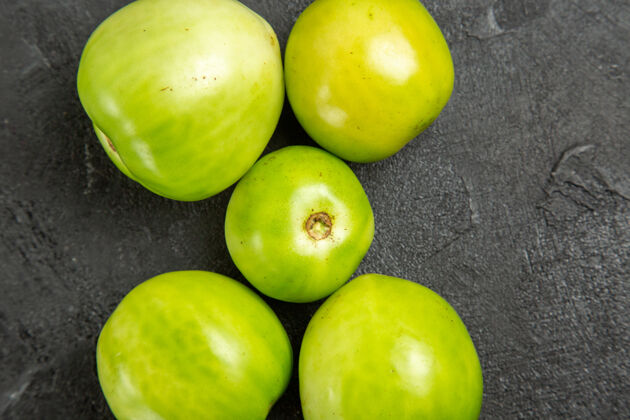 核果顶近看绿色西红柿在黑暗的桌子上与复制空间草本顶部健康