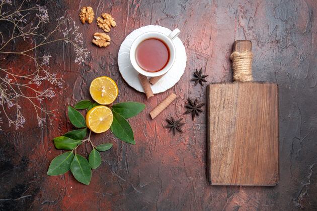 容器俯瞰一杯柠檬茶 放在深色的茶几上 茶是深色的水果茶棕色热的