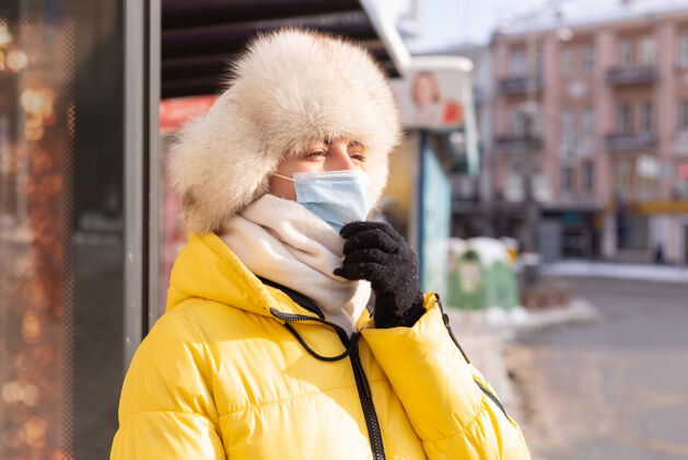 年轻在寒冷的日子里 一个穿着冬衣的女人在公共汽车站等公共汽车等待女孩肖像