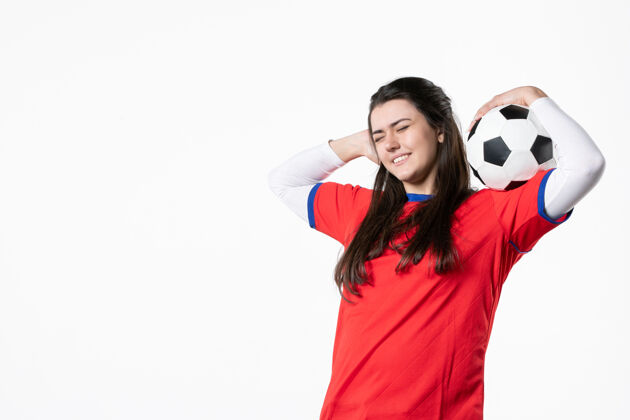 前面正面图微笑的年轻女子穿着运动服拿着足球运动足球球员