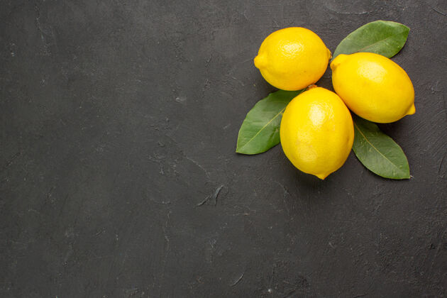 复制空间顶视图新鲜的酸柠檬和叶子放在深色的餐桌上 橙黄色的柑橘类水果健康背景深色