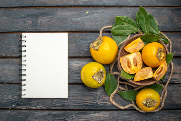 成熟俯瞰木质质朴的餐桌上新鲜甜甜的柿子 品尝成熟的水果黄色注意柑橘