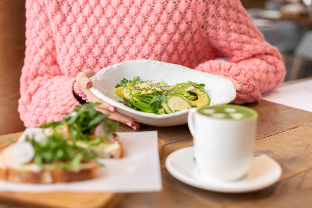 盘子餐厅提供健康早餐绿色沙拉 芝麻菜 三文鱼和抹茶拿铁烹饪蔬菜膳食