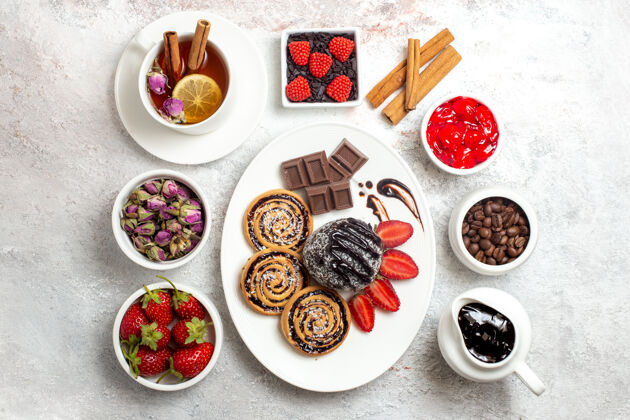 餐顶视图甜饼干巧克力蛋糕和茶白色背景甜饼干糖蛋糕饼干视图餐厅早餐