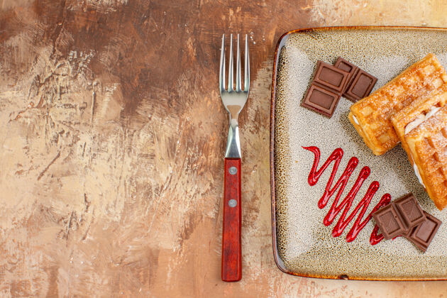 厨具俯瞰美味的华夫饼与巧克力条棕色背景巧克力器皿炊具
