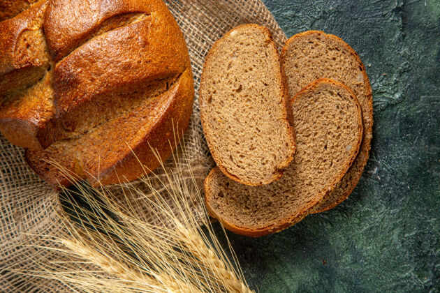 香料俯视图整体和削减膳食黑面包和钉子在棕色毛巾上的深色表面整个早餐谷物