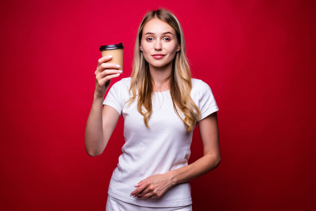 姿势一个美丽的女人拿着一个纸杯去喝咖啡 隔着红墙女孩约会女人
