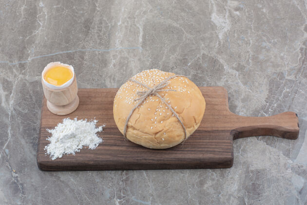 蛋黄在木板上放一块蛋黄和面粉的白面包面包糕点小面包