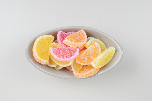 切片甜甜的彩色果冻糖果在米色的碗表面美味零食糖果
