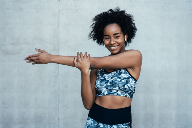 健身房一位非洲运动妇女在户外运动前伸展双臂热身肖像成人黑人