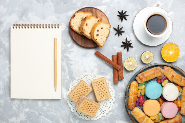饼干顶视图一杯白面包圈和麦卡龙茶杯子茶笔记本
