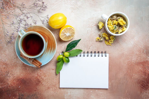 早餐顶部特写查看一杯茶一杯茶肉桂柠檬白笔记本草药热的早晨食物
