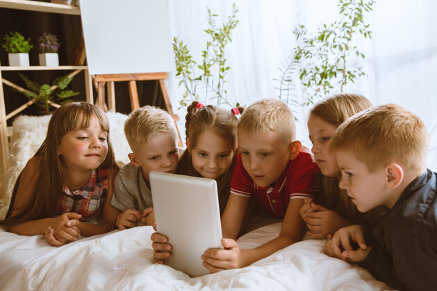 肖像男孩和女孩使用平板电脑孩子房间童年