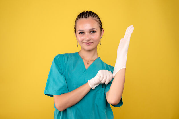 手套黄墙上戴着特制手套的女医生正面图健康休闲成人
