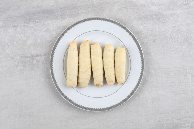 饼干把饼干放在盘子上 放在大理石桌上点心甜点面包卷