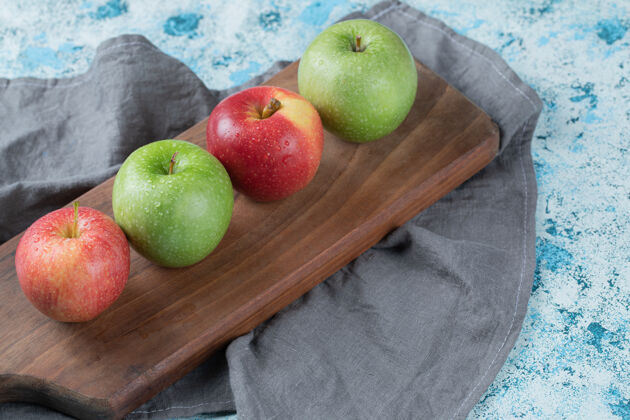 艺术把苹果孤立在一个朴素的木盘上美味酸产品