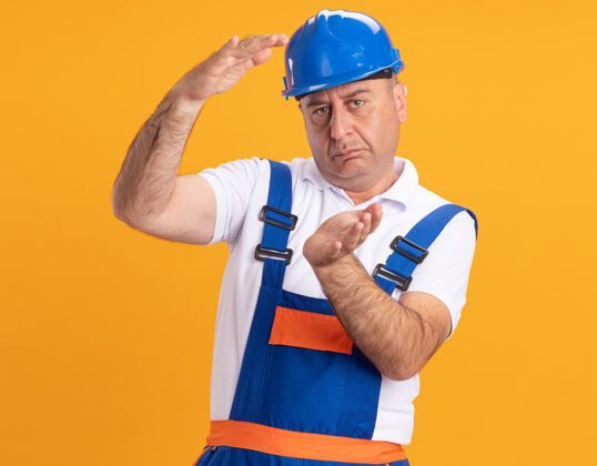 成年人自信的白人成年建筑工人穿着制服假装拿着橙色的东西人制服建筑工人