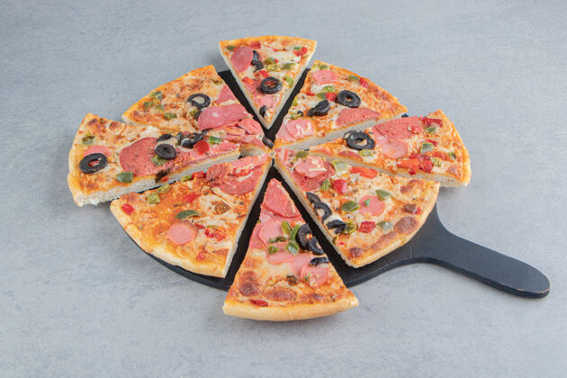 餐盘把比萨饼整齐地放在大理石板上美味香肠垃圾食品