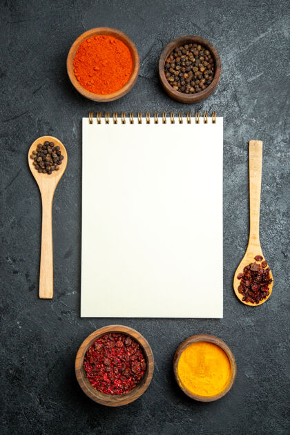 调味品在灰色空间用记事本俯瞰不同的调味品木勺餐具胡椒