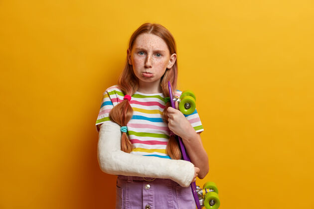 残疾心烦得罪了要哭的女孩 和滑板摆姿势 想有一个积极的暑假 在绷带石膏断了胳膊 过着运动的生活方式 做了危险的把戏后断了胳膊小闷闷不乐沮丧
