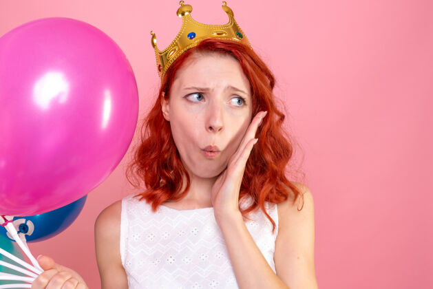 五颜六色前方近景年轻女子手持五颜六色的气球忧心忡忡的粉红色头发公主派对