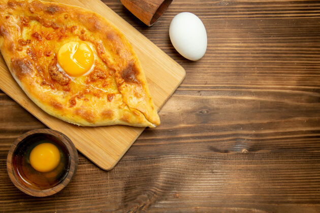 蛋俯瞰美味的鸡蛋面包烤在棕色木桌面包烤早餐鸡蛋奶酪比萨饼晚餐