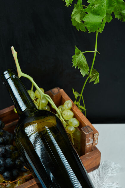 葡萄酒白色桌子上的一串葡萄和一个酒瓶 特写高质量照片树叶葡萄水果
