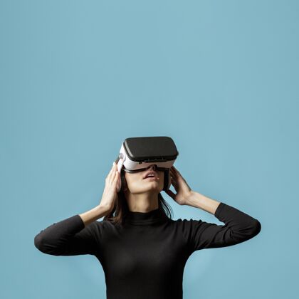 虚拟现实眼镜戴着虚拟现实耳机的肖像女人仿真虚拟现实耳机虚拟现实