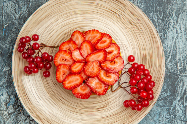 葡萄干在黑暗的表面上有红色浆果的美味草莓蛋糕的俯视图甜点多汁深色