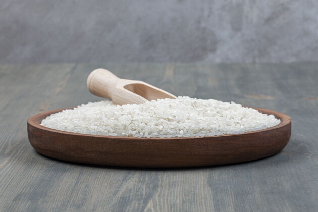 种子健康的生米用木勺放在木桌上食物勺子餐桌
