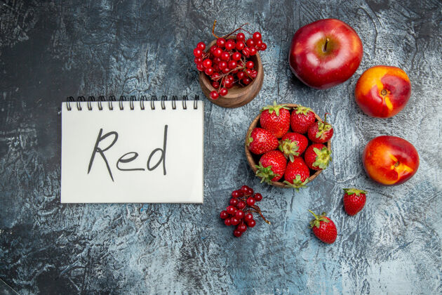 记事本新鲜水果的顶视图 黑色表面上有红色书写的记事本草莓深色成熟