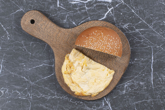 片把煎蛋卷和小面包放在砧板上美味切片小面包