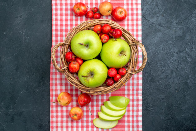 水果顶视篮上有水果绿色的苹果和甜樱桃在深灰色的桌上水果浆果组成的新鲜树樱桃篮子生的