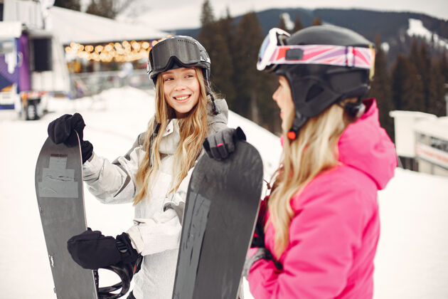 高山穿着滑雪板套装的女人在山上的运动员手拿滑雪板在地平线上关于运动的概念女性成人下雪