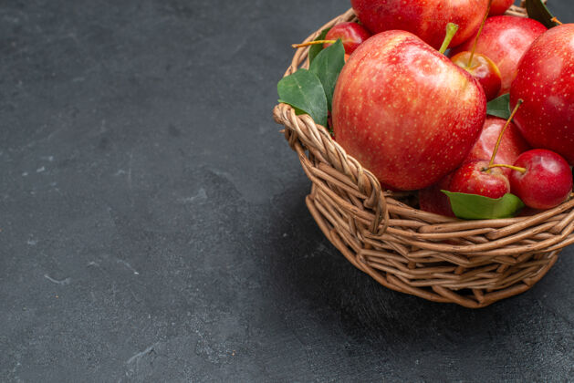 苹果侧面特写查看水果开胃的苹果和樱桃在篮子里篮子萝卜樱桃