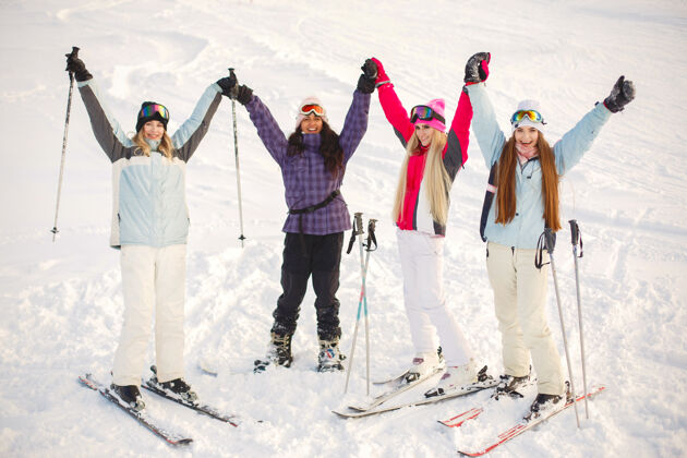 冬天女孩们在雪地里滑雪 享受拍照的乐趣 在山上度过时光山腰寒冷滑雪
