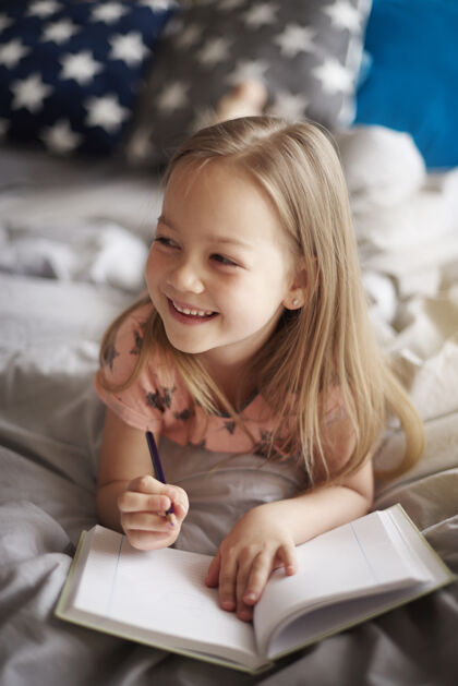 童年小女孩在床上画画的特写肖像绘画天真后代