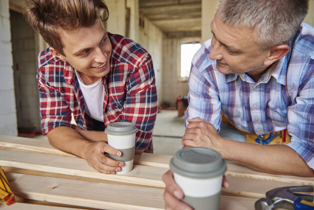 设备工人们一边喝咖啡一边聊天木工合作沟通
