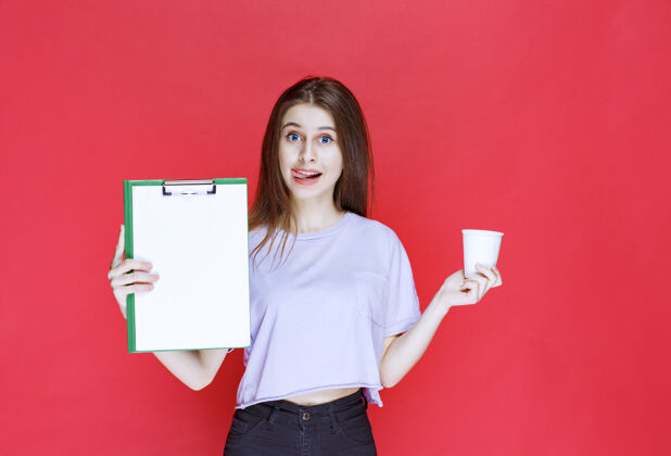 员工年轻女子拿着报告单和一杯饮料人工作孤立