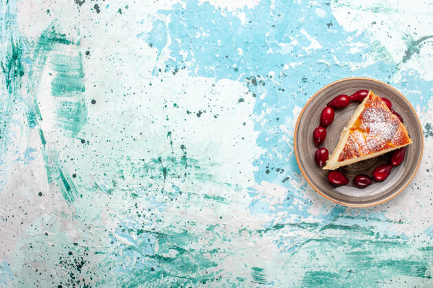 水果顶视图蛋糕片与新鲜的红山茱萸在浅蓝色背景上水果蛋糕烘烤派糖饼干甜切片视野桌子