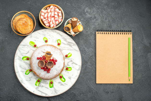 游戏设备从远处俯瞰一个蛋糕一个开胃蛋糕与浆果饼干糖果华夫饼笔记本铅笔陶器糖果芯片