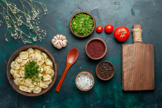 胡椒俯瞰美味的饺子汤 用不同的调味料放在深绿色的汤面上 汤食肉食蔬菜面团肉饺子晚餐